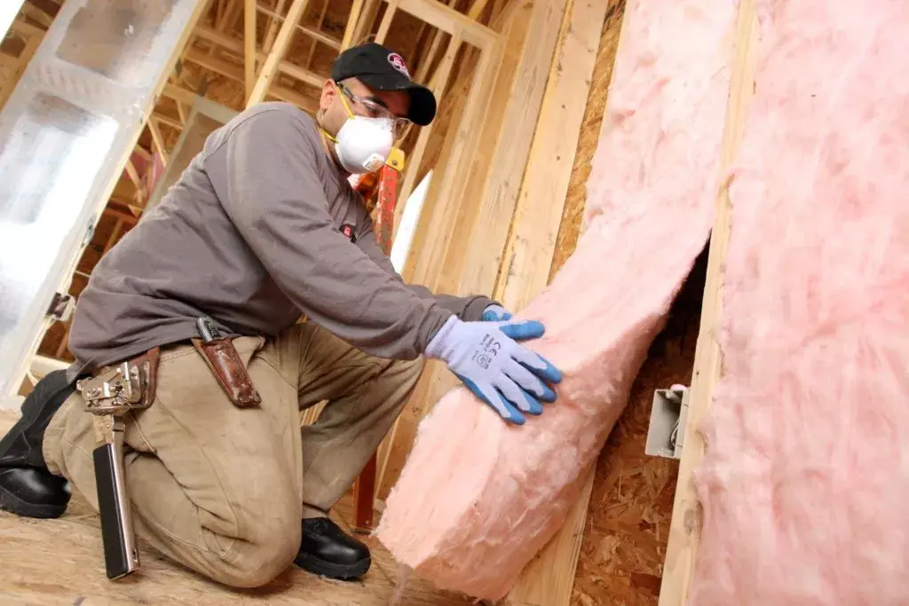 worker insulating the wall