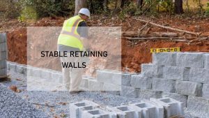 a man in a hard hat and yellow vest building a wall